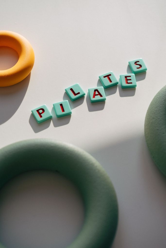 Top view of colorful foam rings and PILATES text, perfect for fitness themes.